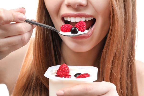 A woman eating yogurt for better gut health.