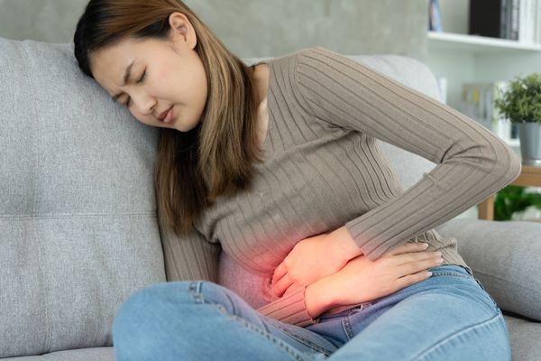 Woman experiencing stomach discomfort from unhealthy gut